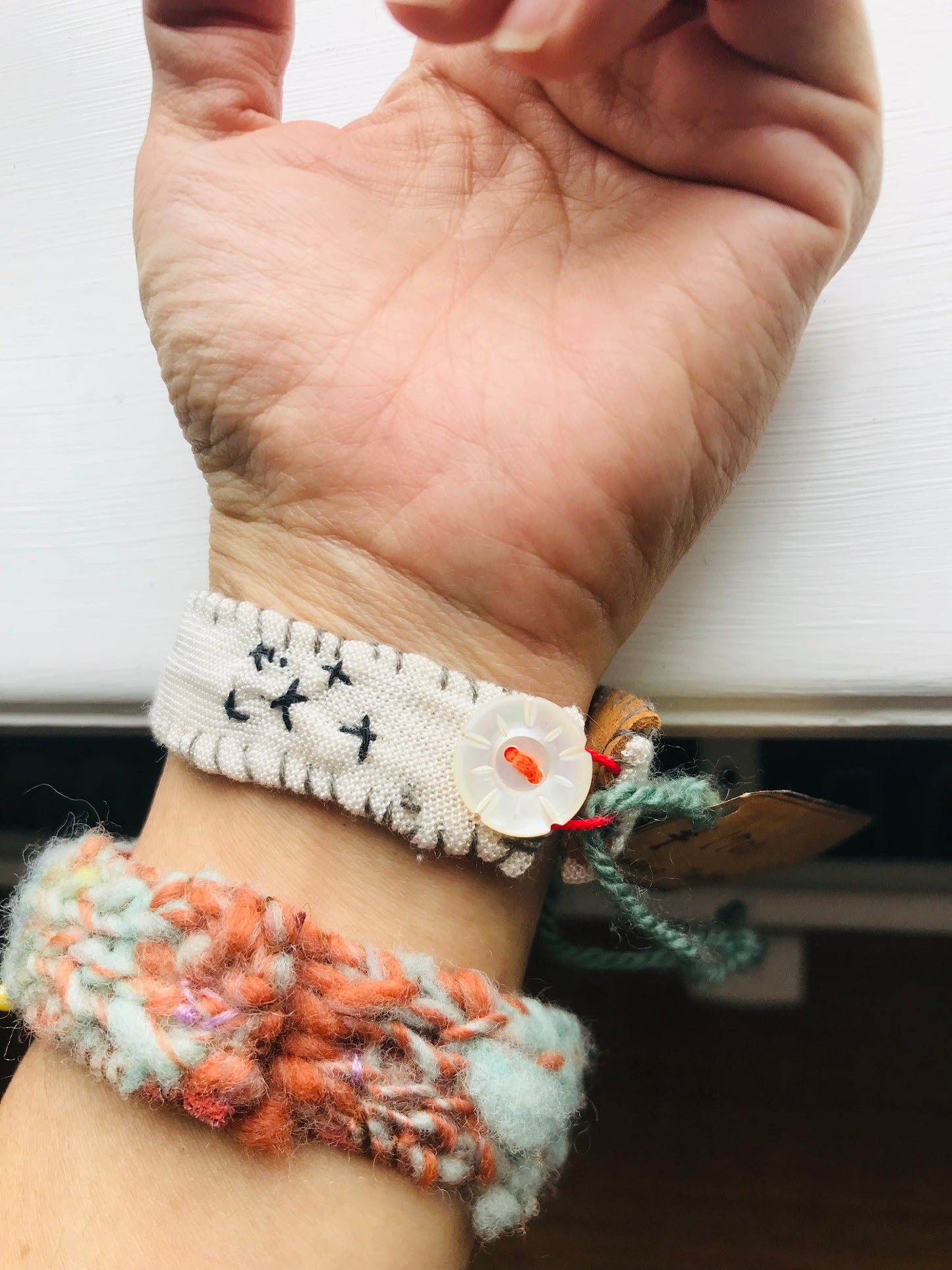 Håndsyede stofarmbånd med håndspundet garn og perlebroderi. 2048