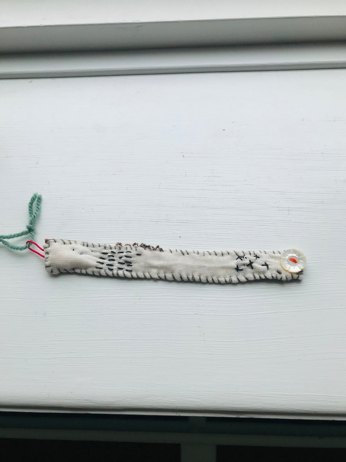 Håndsyede stofarmbånd med håndspundet garn og perlebroderi. 2048
