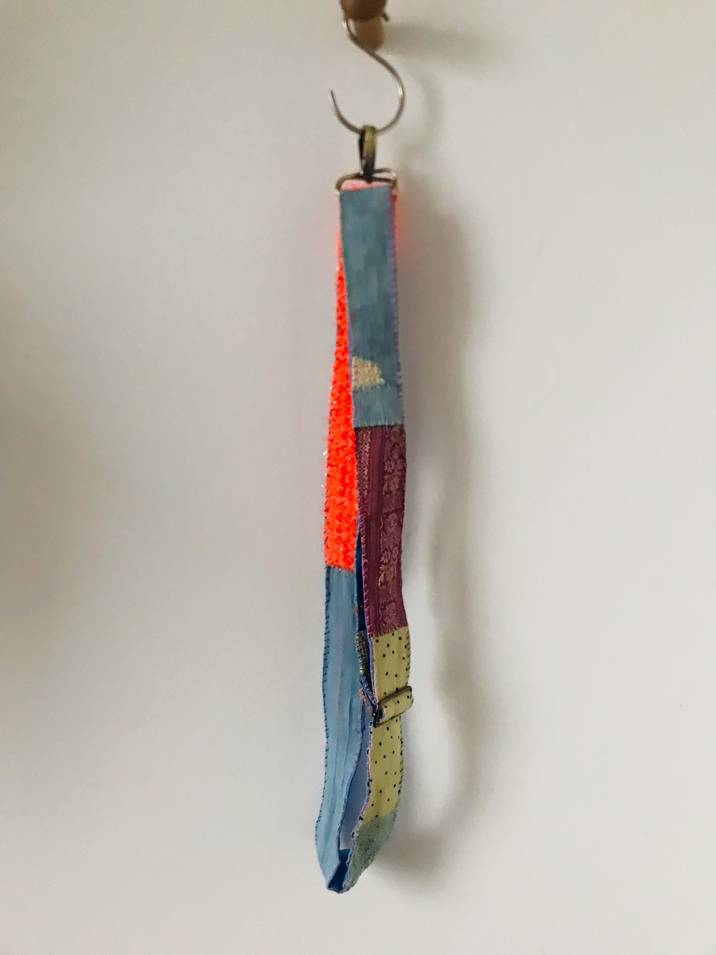 Håndstrikket rem lavet af uld, stof og garn. Et håndlavet stykke slow-fashion. Produktkode: 2122.