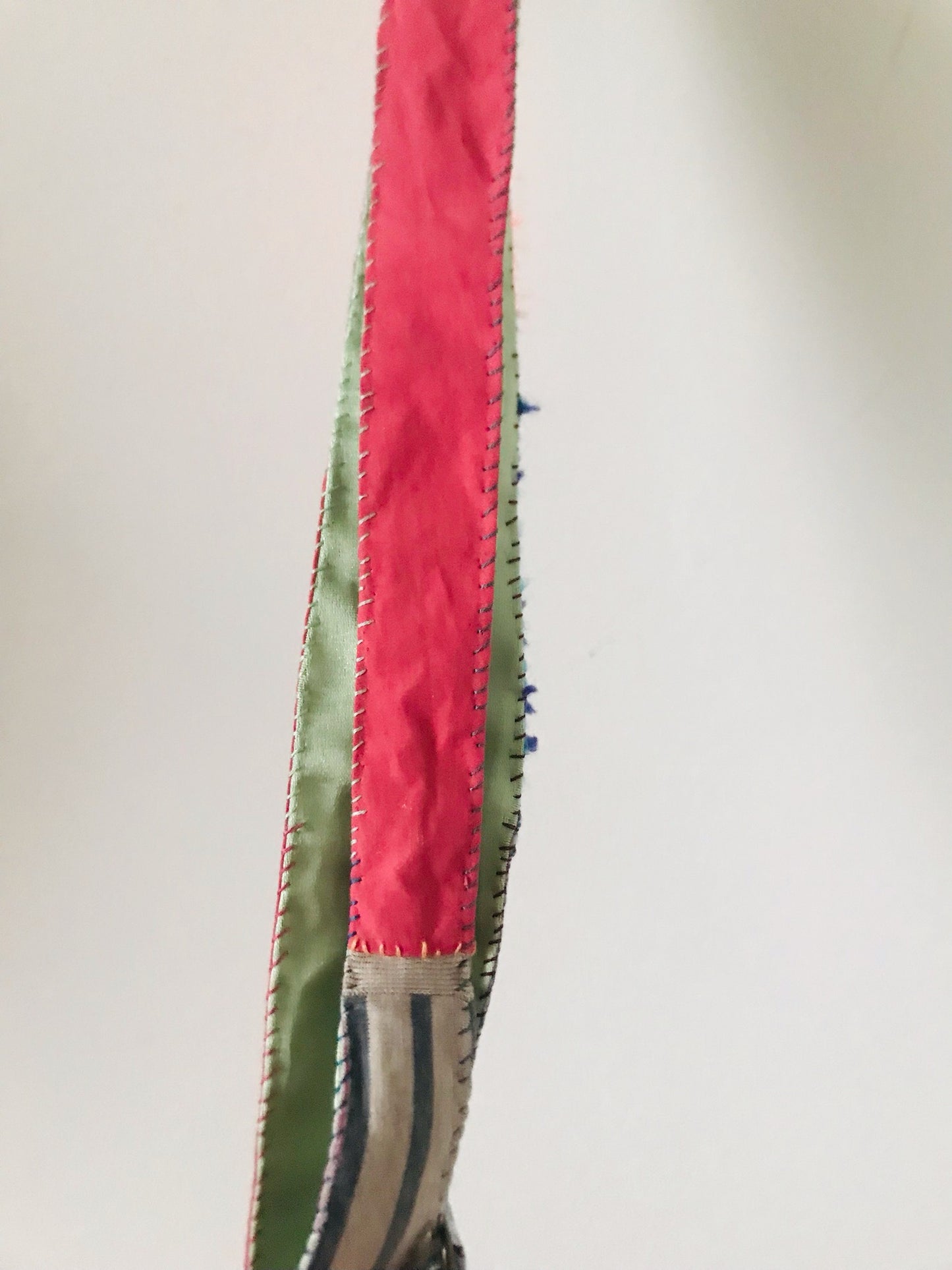 Håndstrikket rem lavet af uld, stof og garn. Et håndlavet stykke slow-fashion. Produktkode: 2117.