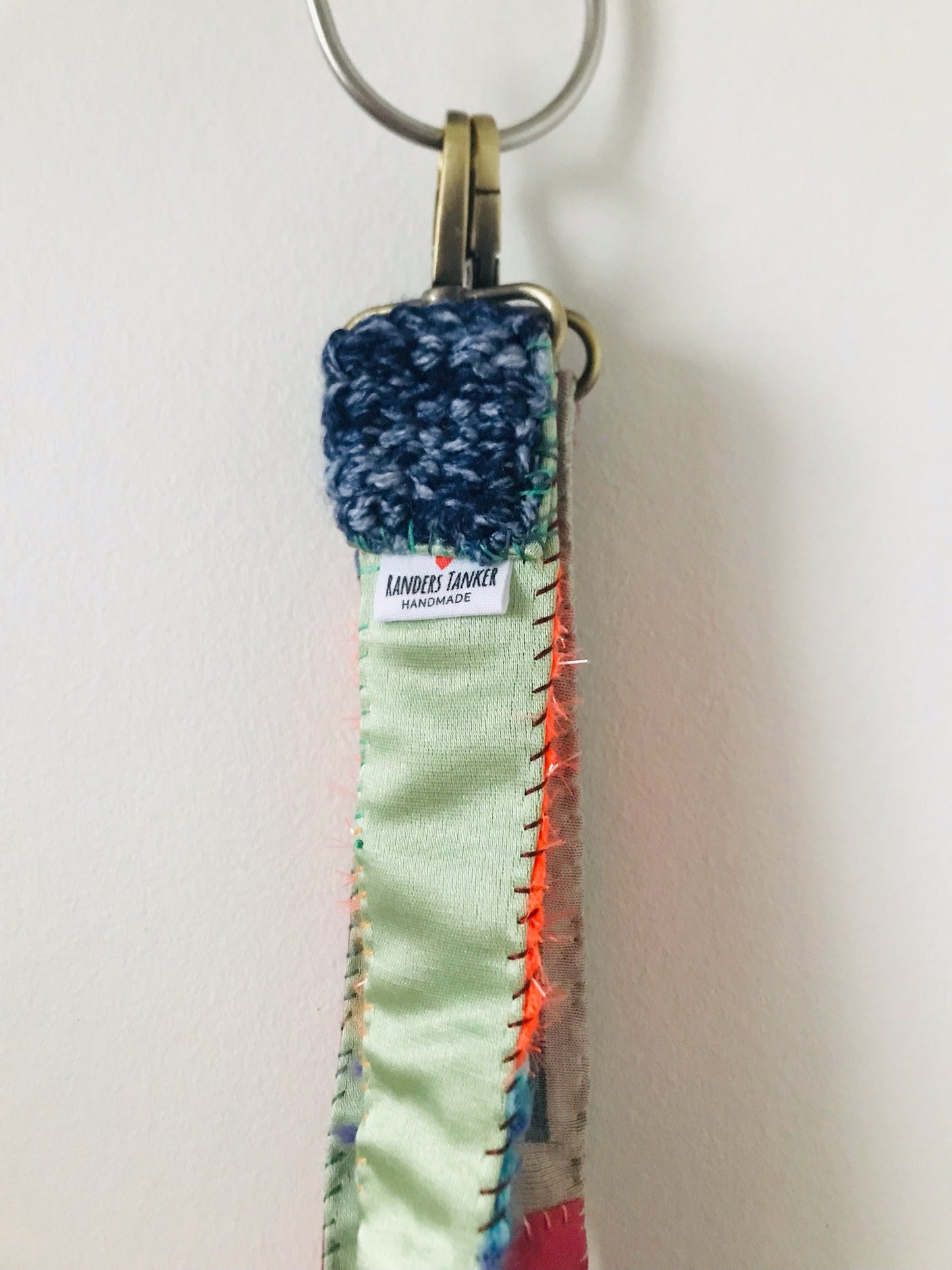 Håndstrikket rem lavet af uld, stof og garn. Et håndlavet stykke slow-fashion. Produktkode: 2117.