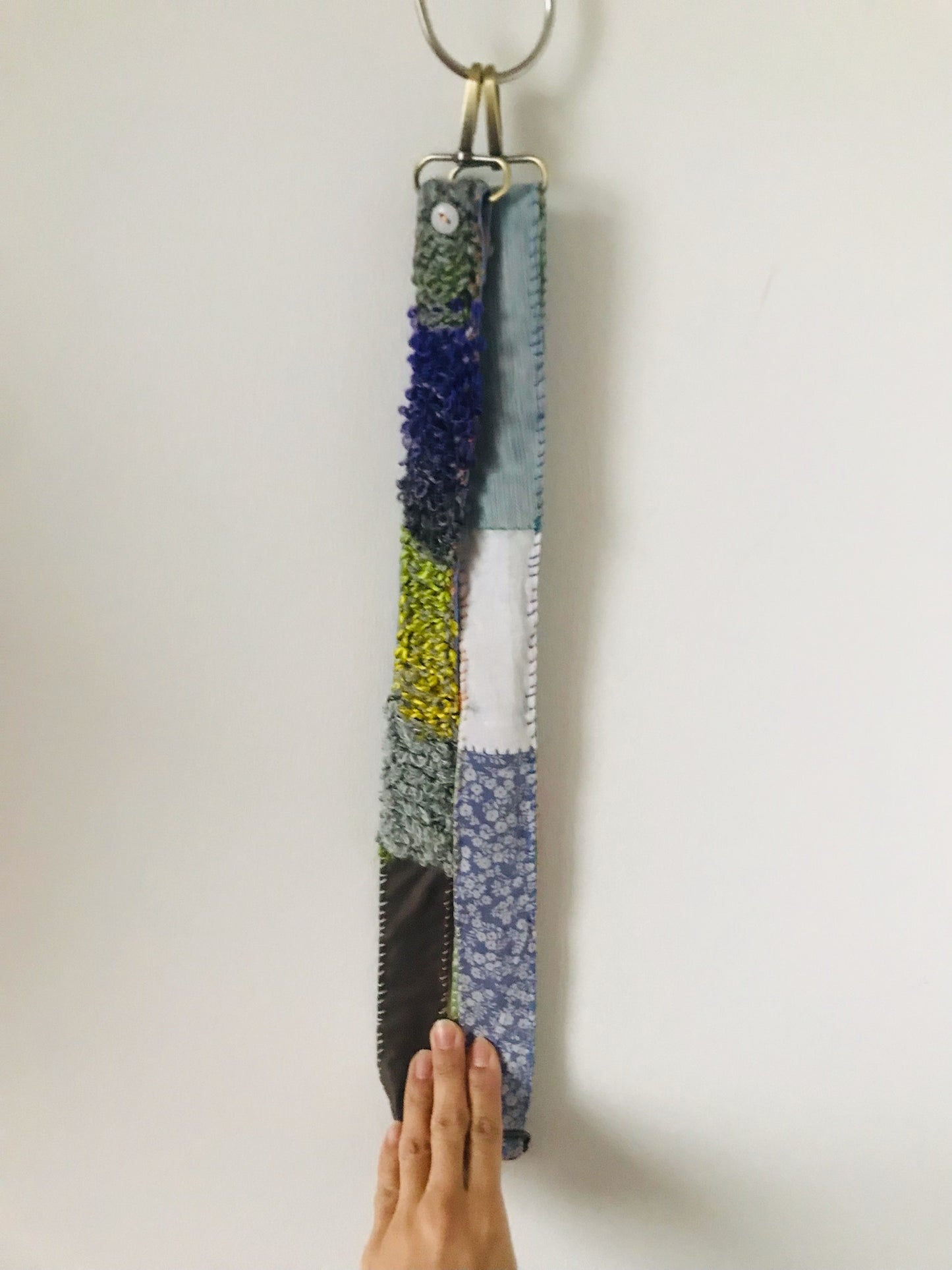 Håndstrikket rem lavet af uld, stof og garn. Et håndlavet stykke slow-fashion. 2120