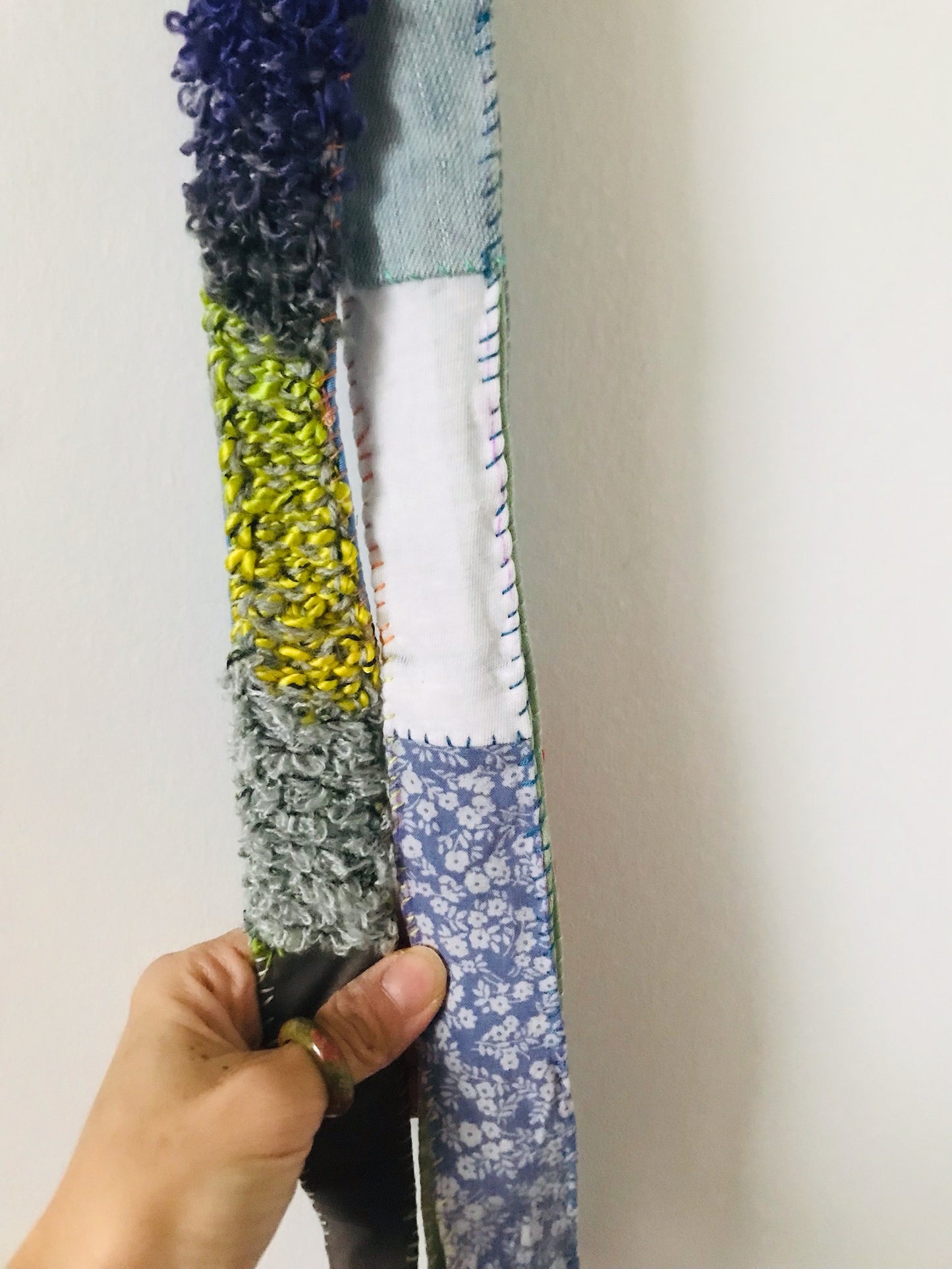 Håndstrikket rem lavet af uld, stof og garn. Et håndlavet stykke slow-fashion. 2120