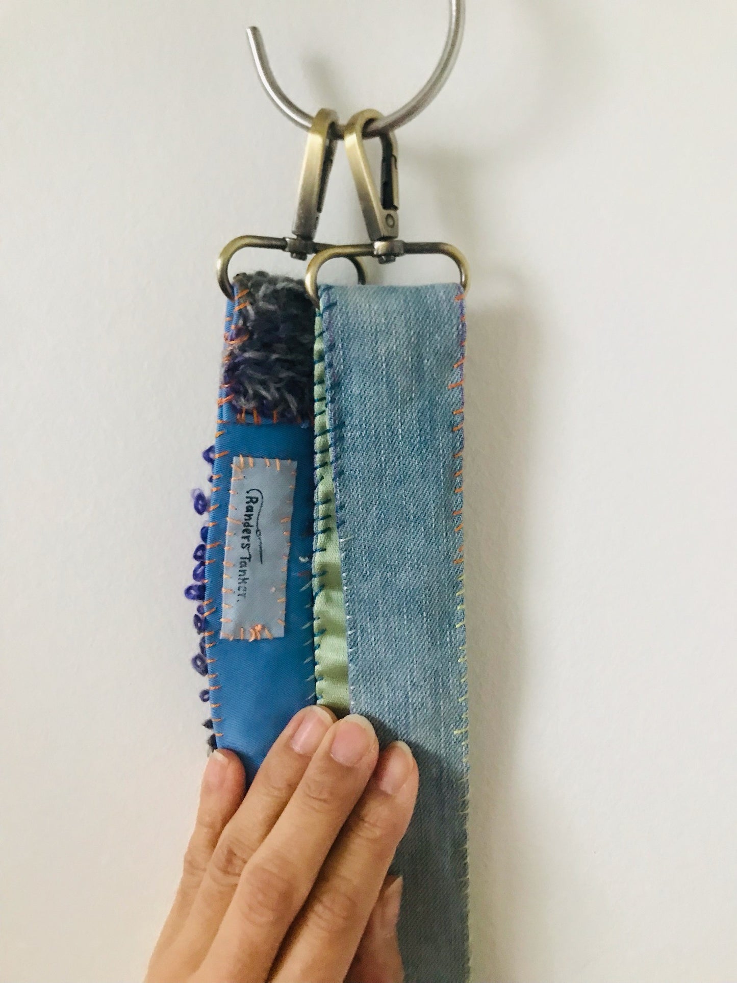 Håndstrikket rem lavet af uld, stof og garn. Et håndlavet stykke slow-fashion. 2120