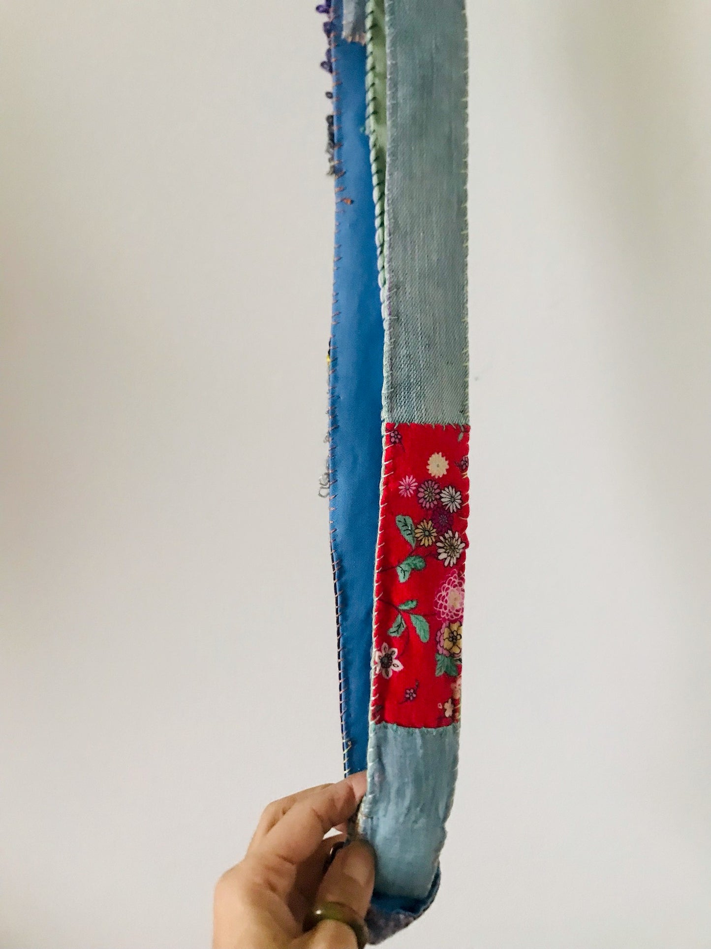 Håndstrikket rem lavet af uld, stof og garn. Et håndlavet stykke slow-fashion. 2120